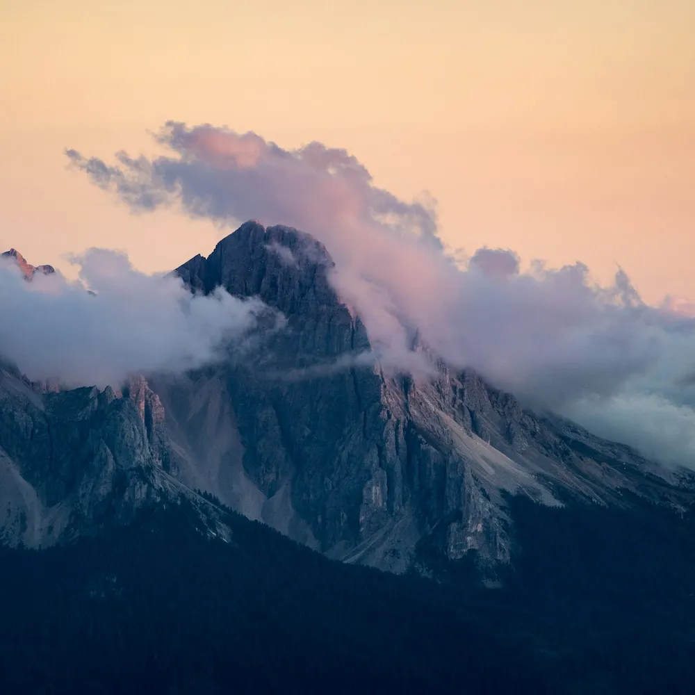 A mountain peak emerging through cloud at golden hour