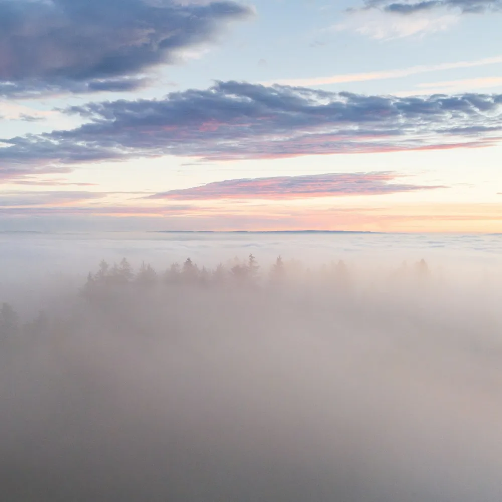 Soft clouds parting over a distant horizon at dawn